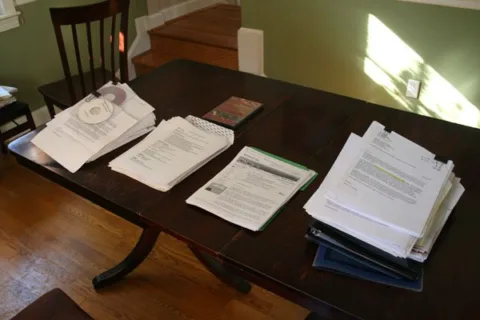 Stacks of actor headshots and acting resumes sitting on a casting directors table
